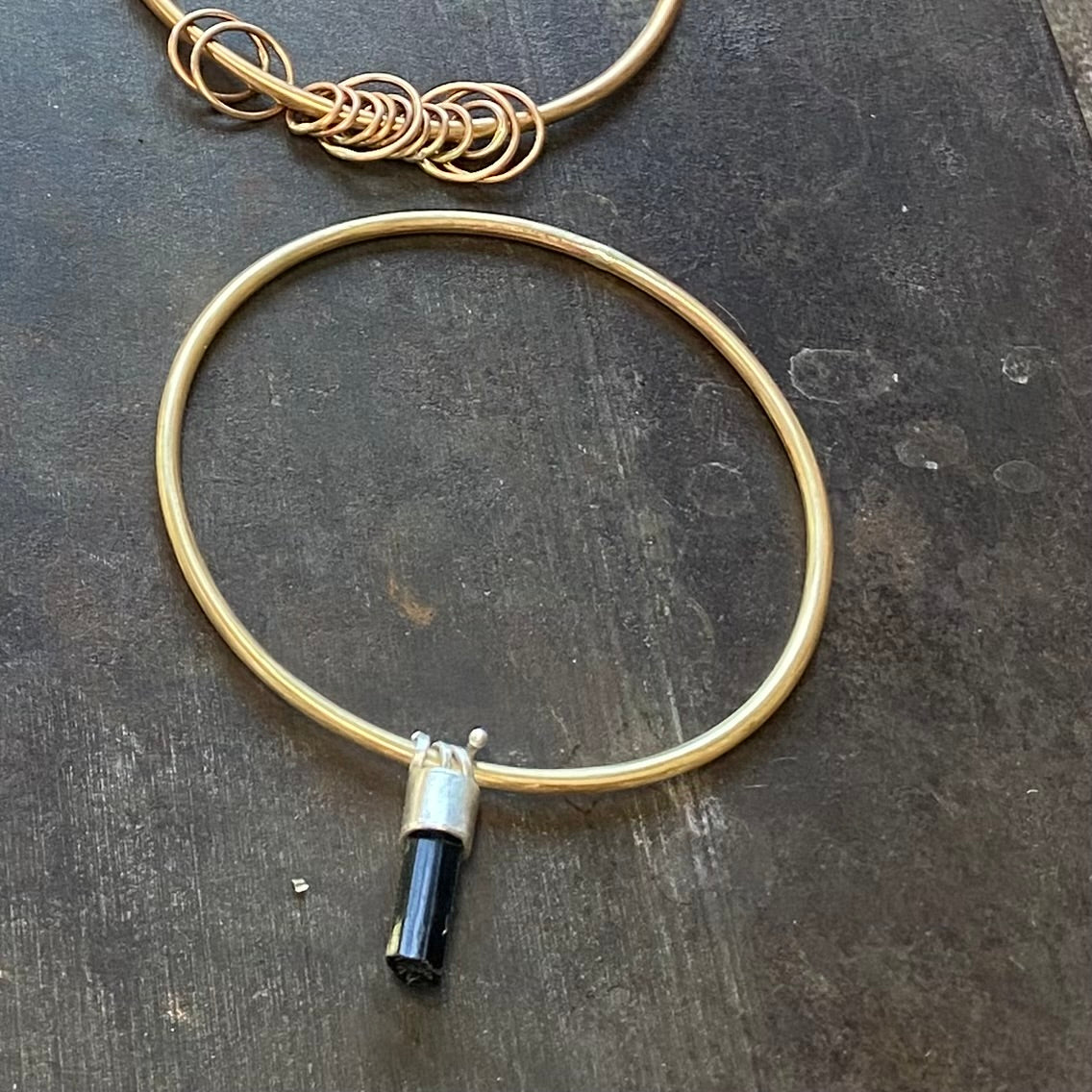 Edgy brass bangle with dangling black tourmaline