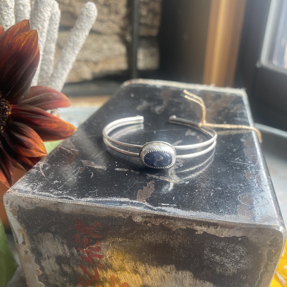 Close-up of hand-cut iolite gemstone set in handmade sterling silver cuff